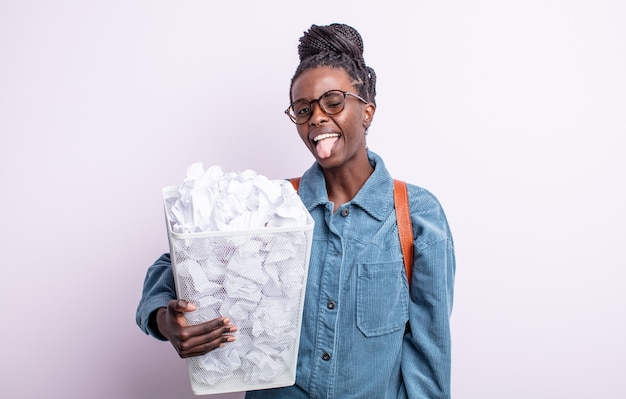 Bonita mujer negra con actitud alegre y rebelde, bromeando y sacando la lengua. concepto de falla de bolas de papel