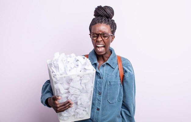 Bonita mujer negra gritando agresivamente, luciendo muy enojada. concepto de falla de bolas de papel