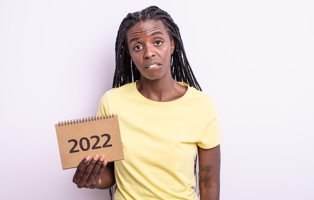 bonita mujer negra que parece desconcertada y confundida. concepto de calendario 2022