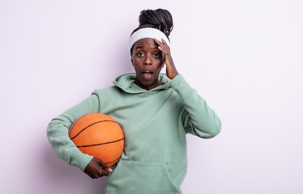 Bonita mujer negra que parece feliz, asombrada y sorprendida. concepto de baloncesto