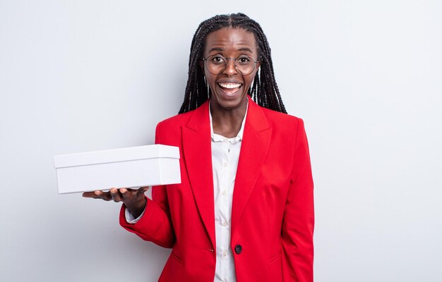 Bonita mujer negra que parece feliz y gratamente sorprendida. mujer de negocios, con, un, caja blanca