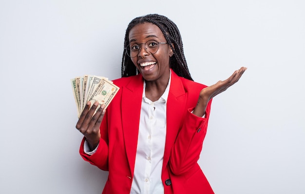 Bonita mujer negra que se siente feliz y asombrada por algo increíble. concepto de billetes de dólar