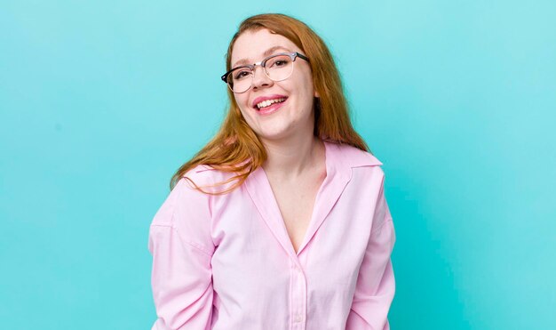 Bonita mujer pelirroja con una gran sonrisa amistosa y despreocupada que parece positiva, relajada y feliz escalofriante