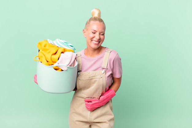 Bonita mujer rubia riendo a carcajadas de una broma divertida concepto de lavado de ropa