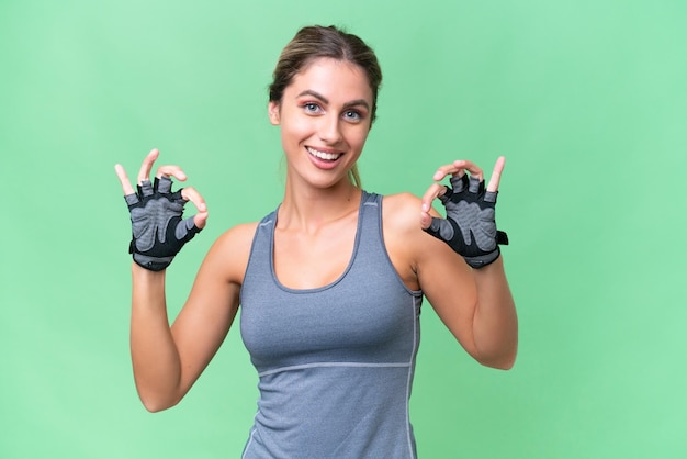 Foto bonita mujer uruguaya deportiva sobre un fondo aislado que muestra un signo de ok con los dedos