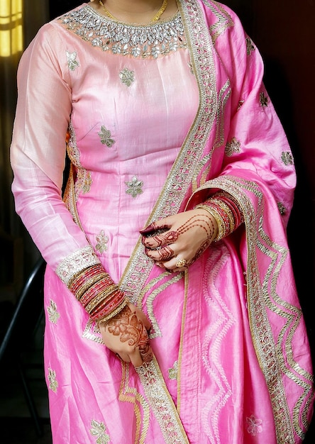 Bonita novia india en vestido rosa de pie y lista para una pose.