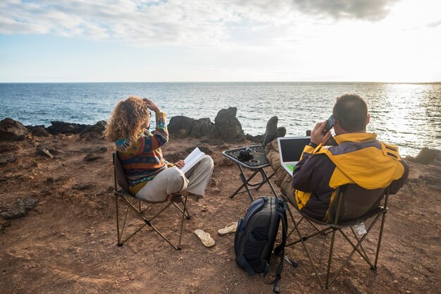 Bonita pareja disfrutando de una puesta de sol al final del día, estilo de vida de viaje en pasión por los viajes para personas felices de raza caucásica que trabajan en una oficina alternativa con una computadora portátil y conexión móvil a fotógrafos de Internet