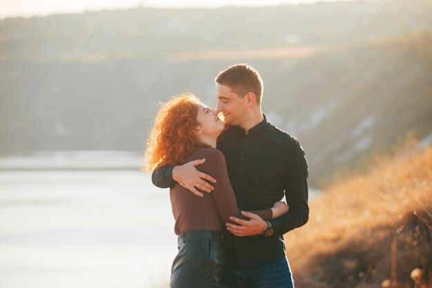 Bonita pareja pasando un rato maravilloso juntos abrazándose en un campo