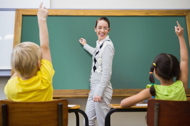 Bonita profesora escribiendo en pizarra