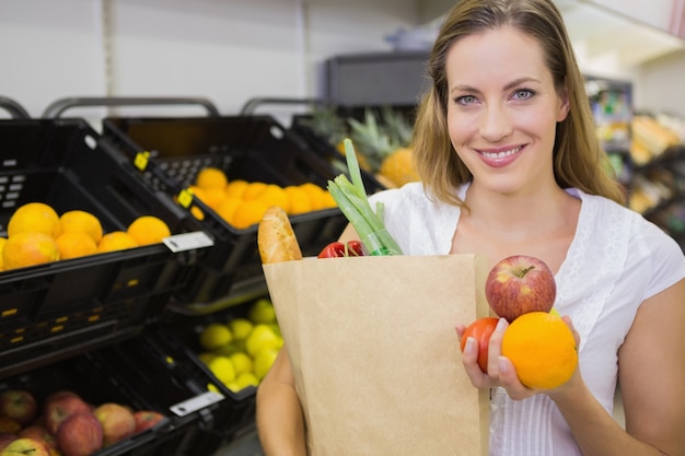 una bonita rubia con una bolsa de supermercado