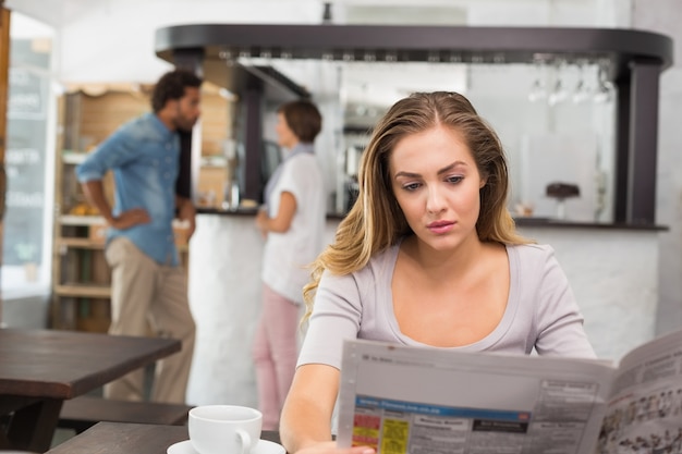 Bonita rubia leyendo el periódico