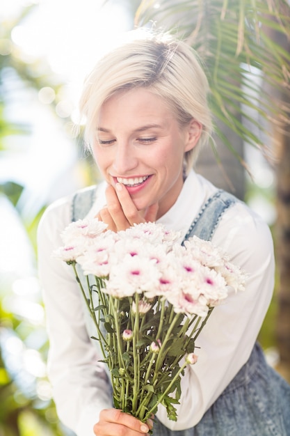 Bonita rubia mujer sosteniendo ramo de flores