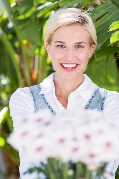 Bonita rubia mujer sosteniendo ramo de flores