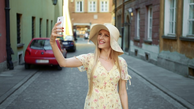 Bonita rubia tomando una foto en la ciudad