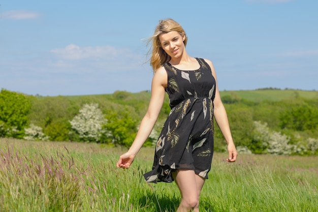 Bonita rubia en vestido de verano sonriendo a la cámara