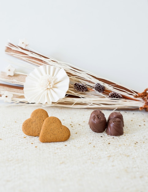 Bonita tarjeta con decoración floral y chocolates para el día de San Valentín.