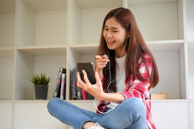 Bonitas adolescentes asiáticas disfrutan hablando por videollamadas por teléfono con sus amigos