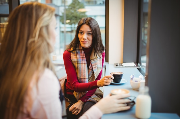 Bonitas amigas charlando tomando un café