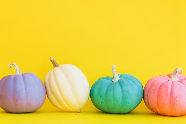 Foto bonitas calabazas decorativas de colores en un fondo amarillo con espacio de copia halloween o acción de gracias