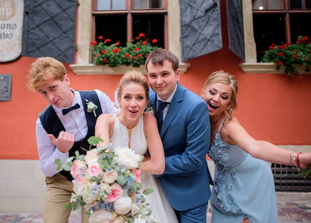 Bonitas novias y sus amigos se divierten posando en la calle