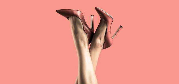 Foto bonitas piernas femeninas con tacones rojos sobre fondo rojo. perfectas piernas femeninas con tacones altos. piernas bien formadas, una chica con zapatos de tacón alto.