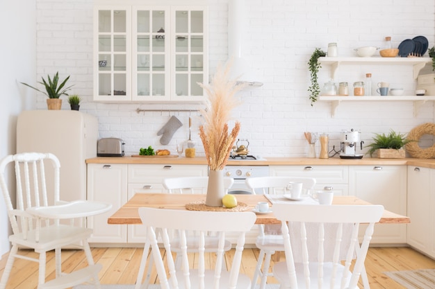 Interior de cocina rústica con pared de ladrillo blanco y estantes de madera  blanca