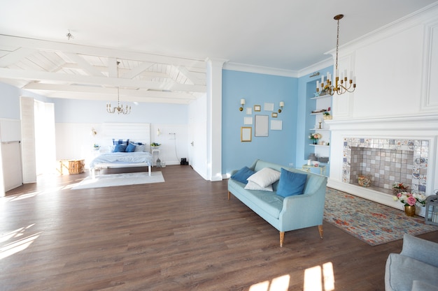 Bonito y acogedor interior de una amplia habitación en suaves tonos azules.
