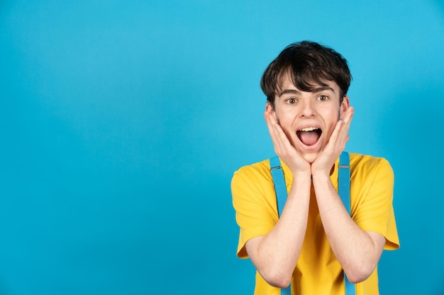 Bonito adolescente surpreso com espaço de cópia azul