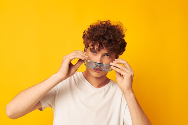 Bonito cara ruivo em óculos azuis camiseta branca moda estilo moderno fundo amarelo inalterado