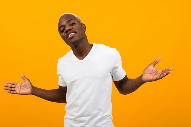 Bonito charmoso preto americano homem bonito em t-shirt branca braços abertos em amarelo