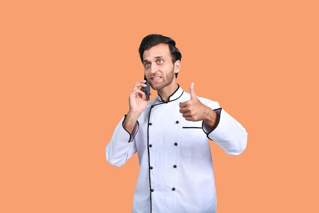 bonito chef falando no telefone roupa branca modelo paquistanês indiano