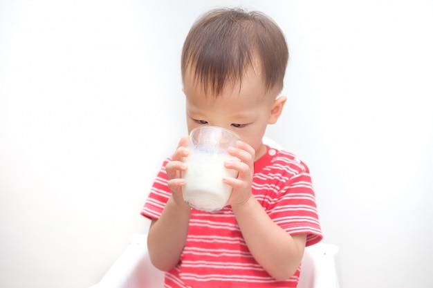 Bonito criança asiática menino criança beber leite de um copo