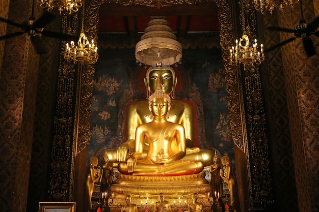 Bonito da estátua dourada da Buda e da arquitetura tailandesa da arte no templo de Tailândia.