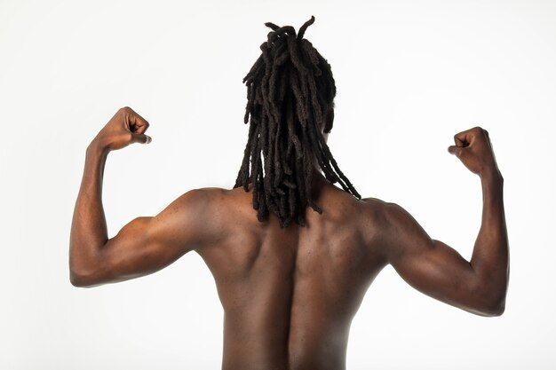 bonito e elegante homem africano com cabelo de dreadlocks em um fundo branco com músculos