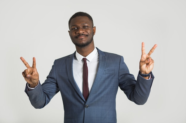 bonito e elegante homem africano de terno em fundo cinza com gesto de mão