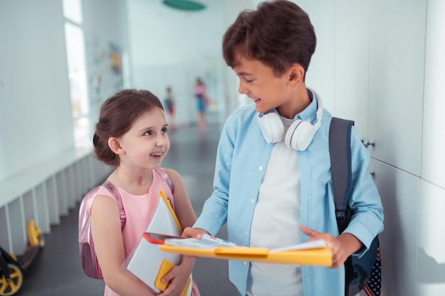 Bonito estudante falando com seu amigo na escola