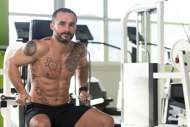 Bonito Fisiculturista Muscular Fitness Fazendo Exercícios Pesados Para Tríceps Na Máquina No Ginásio