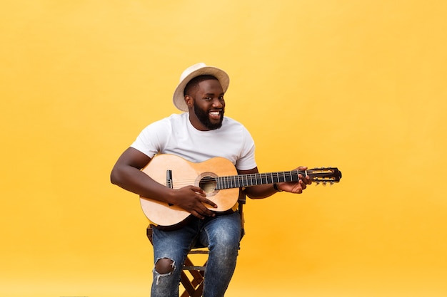 Bonito guitarrista afro-americano de estilo retrô tocando violão