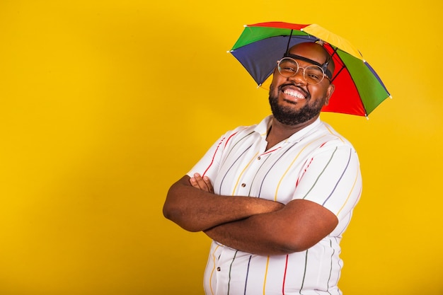 Bonito homem afro brasileiro vestido para carnaval festa típica brasileira festa de carnaval festejando braços cruzados sorrindo para a câmera