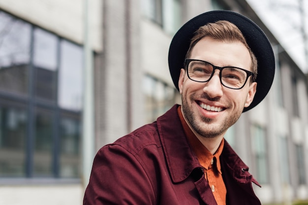 Bonito homem alegre de óculos e chapéu