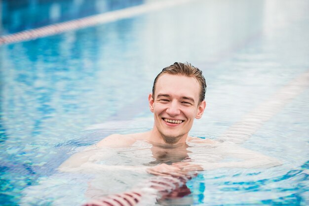 Bonito homem atlético posando em uma piscina