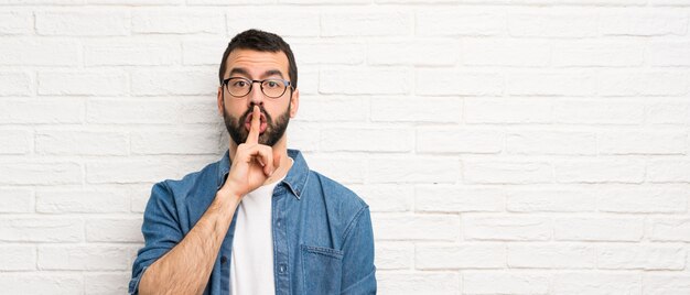 Bonito, homem barba, sobre, branca, parede tijolo, mostrando, um, sinal, de, silêncio, gesto, pôr, dedo boca