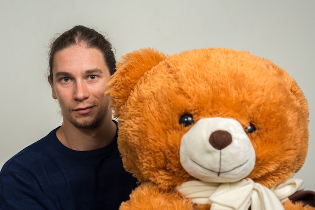 bonito homem barbudo com cabelo comprido contra uma parede branca