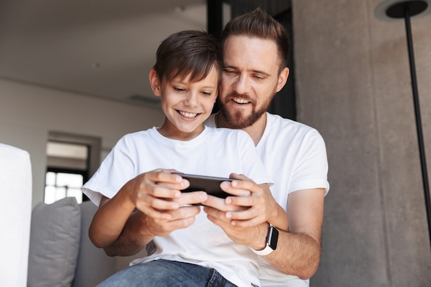 Foto bonito homem barbudo dentro de casa com o filho