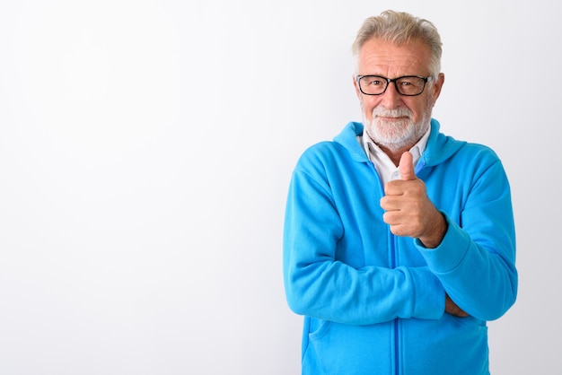 Foto bonito homem barbudo sênior desistindo do polegar, pronto para a ginástica em branco