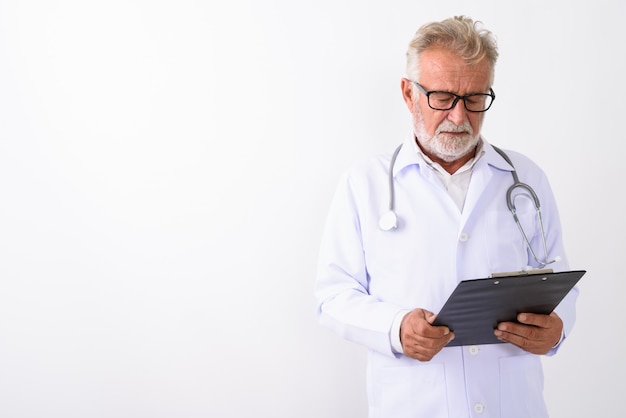 bonito homem barbudo sênior médico lendo na prancheta em branco