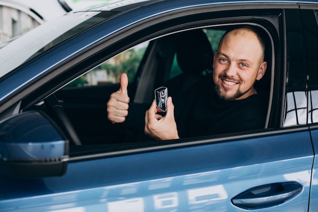 Bonito homem de negócios escolhendo um carro em um showroom de carros