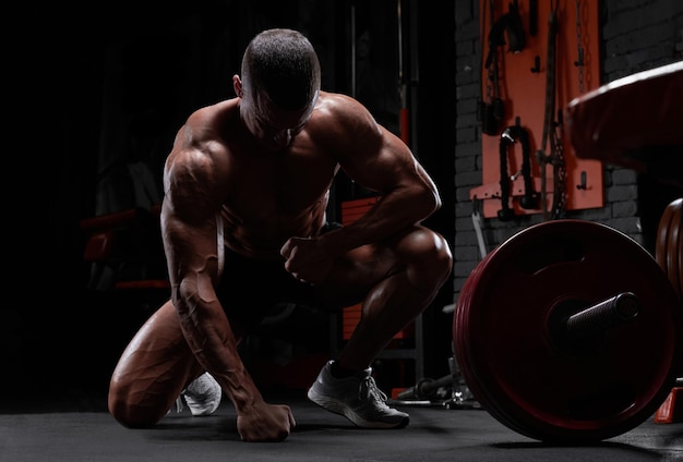 Bonito homem forte atlético bombeando músculos treinando conceito de fisiculturismo musculoso fisiculturista homens bonitos fazendo exercícios no ginásio nu