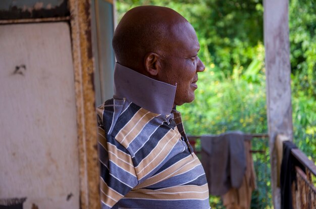 Bonito homem idoso africano vestindo roupas de strip, sentindo-se animado com o que viu em seu telefone.