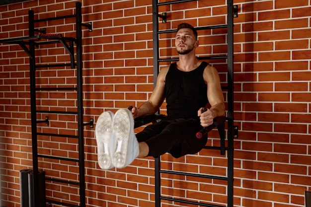 Bonito homem musculoso fazendo exercícios esportivos